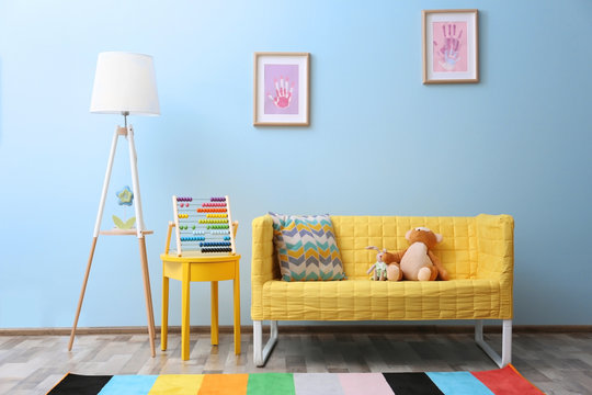 Yellow sofa with toys in children room