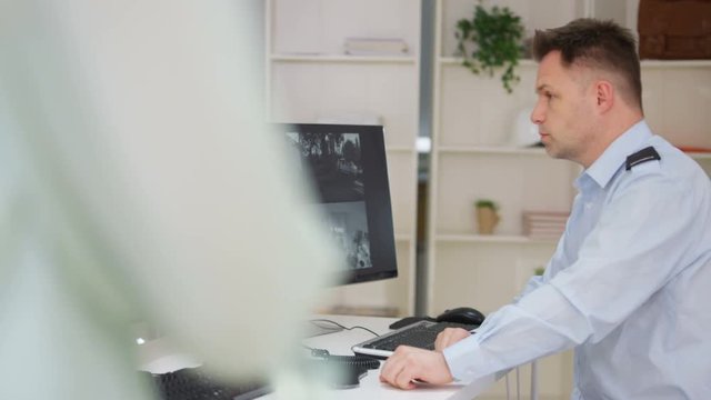  Security worker in system control room gets caught out watching TV on screen.