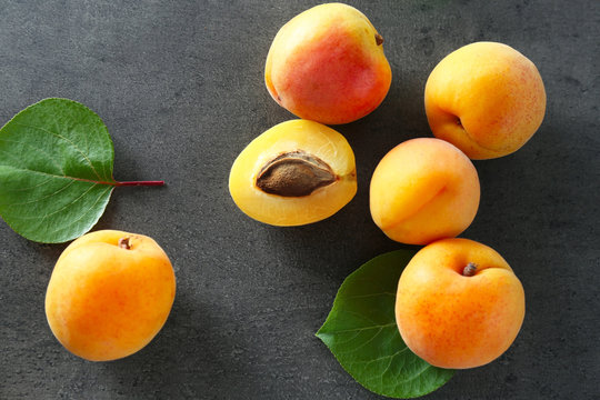 Fresh juicy apricots on grey table