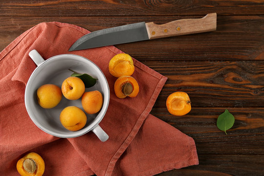 Bowl with apricots and knife on red napkin