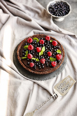 Delicious chocolate tart with berries on a tablecloth