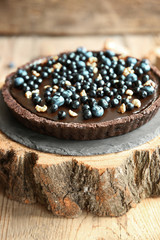 Delicious chocolate tart with blueberry on wooden background