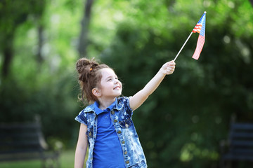 Small girl with American flag in park