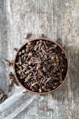 cloves in a bowl on wooden surface