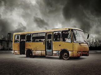 Broken bus on view of city in stormy sky
