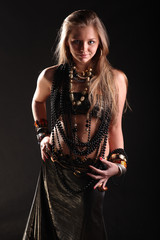 young girl in beads and bracelets on black background