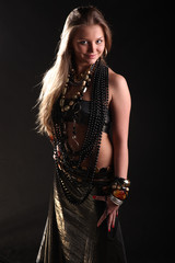 young girl in beads and bracelets on black background