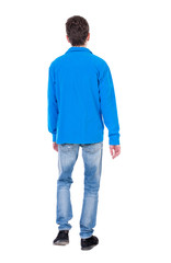 Fototapeta premium Back view of going handsome man. walking young guy . Rear view people collection. backside view of person. Isolated over white background. Curly boy in a warm blue sweater goes out of frame.