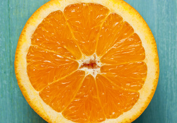 Macro photo of half of vibrant orange on turquoise background