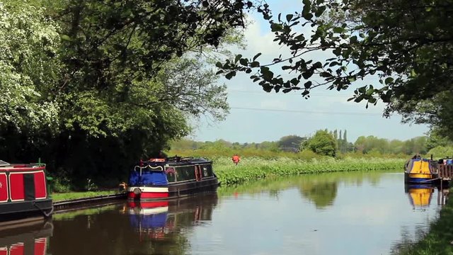 Canal boats moored next to towpath at the side of a canal in central England