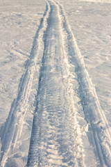 The road in the snow on a snowmobile at sunset
