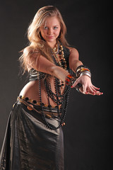 young girl in beads and bracelets on black background