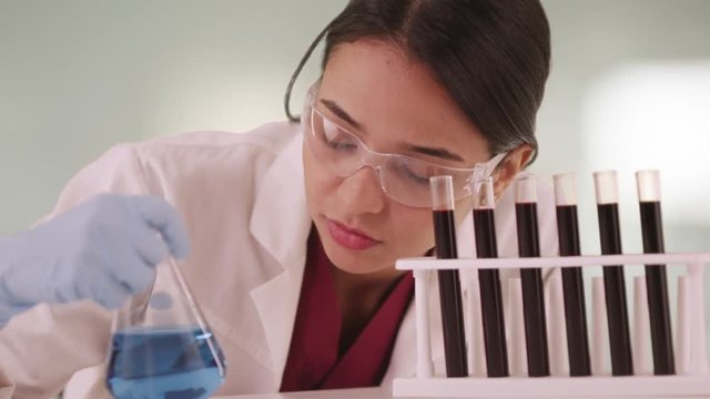 Mexican scientist looking at liquids in vials
