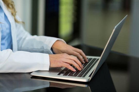 Optometrist using laptop in ophthalmology clinic