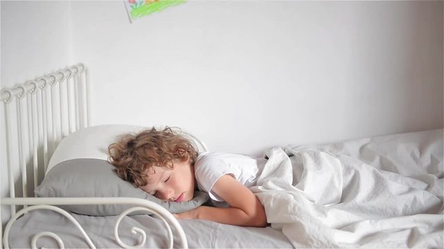 Mother waking up her son, Woman waking her son in bed smiling