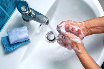 soapy hand over the washbasin - obrazy, fototapety, plakaty