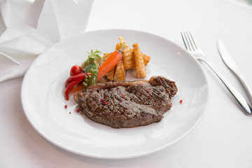 cooked rare sirloin steak  on a white plate