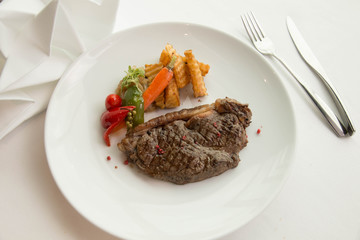 cooked rare sirloin steak  on a white plate