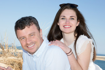 Couple piggyback at beautiful summer beach