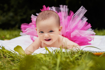 little an infant in a pink skirt laughs