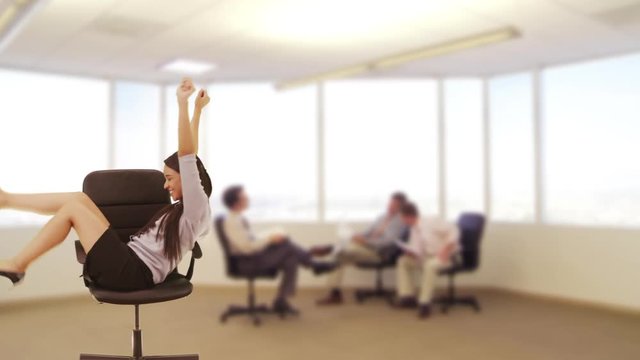 Mexican businesswoman riding chair across the room