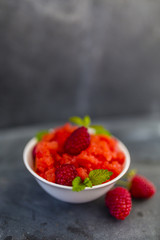 Granita of frozen watermelon with raspberries and lemon balm