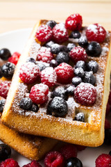 Belgian waffles with fresh berries powdered by caster sugar