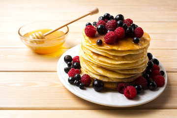 Homemade pancakes with honey and fresh berries