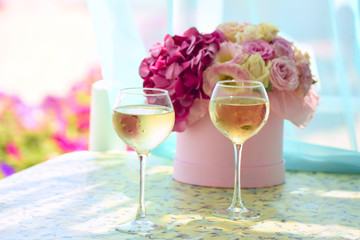 two misted glass of cold champagne in the background delicate bouquet of flowers. sunny, summer, warm, gentle background. Warm summer atmosphere
