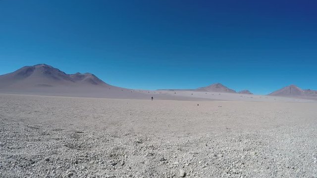 Lonely Silhouette of a Man Walking on a Dry Salt Lake. Salar de Uyuni, Bolivia