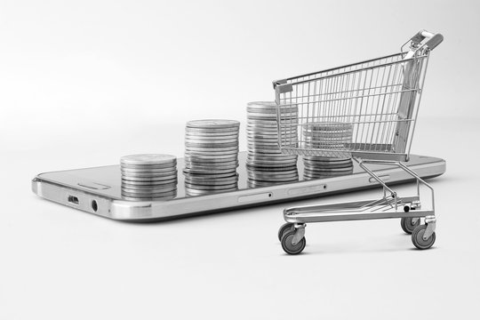 Baht coins, mobile phones, shopping cart on a white background, the concept of online shopping by phone.