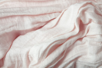 A full page close up of creased pastel pink crepe material texture