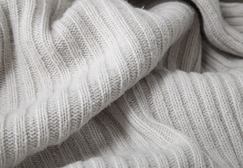 A full page close up of cream chunky knitted jumper fabric texture