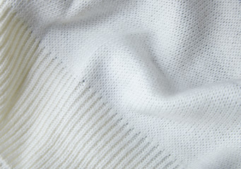 A full page close up of cream knitted sweater fabric texture with ribbed cuff