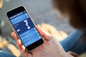 woman sitting in the street holding her smartphone with fitness