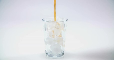 A glass with some ice cubes is standing on a kitchen counter. Someone is pouring some coca cola in it. Close-up shot.
- Powered by Adobe
