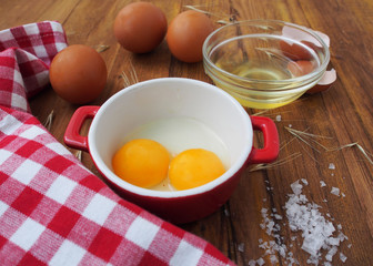 Raw eggs in red and white bowl