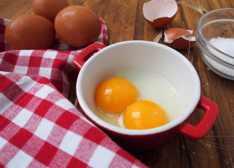 Raw eggs in red and white bowl