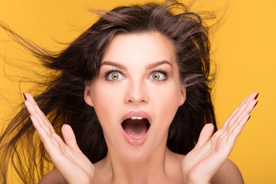 Portrait of brunette girl on yellow background.