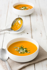 Pumpkin soup in bowl on a white wooden table

