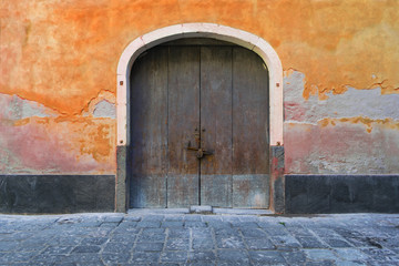 Fototapeta na wymiar Old door in an orange wall