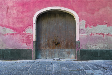 Fototapeta na wymiar Old door in a pink wall