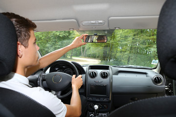 Man adjusting his mirror in a car