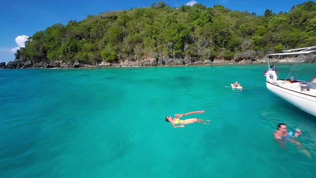 Slow motion video of group of people relaxing and snorkeling from a sailboat in St John, United States Virgin Islands
