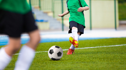 Obraz na płótnie Canvas Football soccer kick. Young player kicking soccer ball