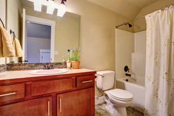 Bathroom with white bath tub, tile floor and vanity cabinet