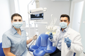 close up of dentist and assistant at dental clinic