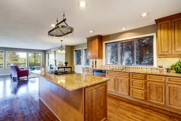 Open floor plan. Kitchen room interior with island and granite counter top.
