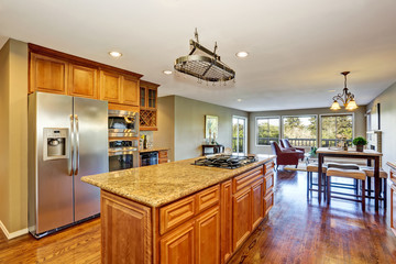 Open floor plan. Kitchen room interior with island and granite counter top.