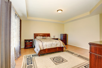 Bedroom interior with wooden furniture, rug and nice brown curtains.
